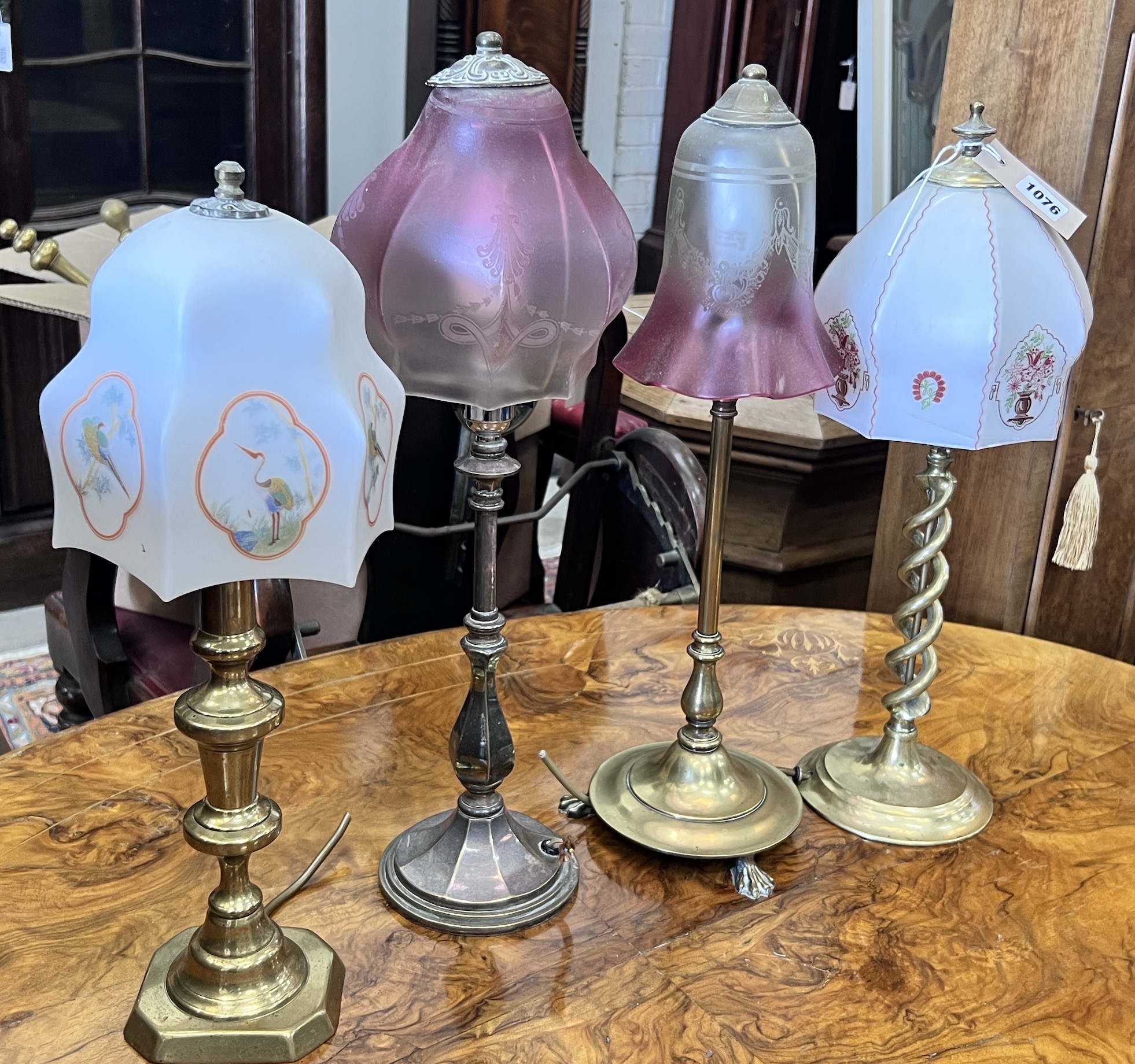 Two Edwardian silver plated and brass table lamps with etched cranberry shades and two converted candlestick lamps, tallest 50cm